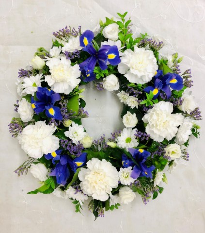 <h2>Extra Large Classic Wreath in Blue and White | Funeral Flowers</h2>
<ul>
<li>Approximate Size W 50cm H 50cm (extra large)</li>
<li>Hand created blue and white wreath in fresh flowers</li>
<li>To give you the best we may occasionally need to make substitutes</li>
<li>Funeral Flowers will be delivered at least 2 hours before the funeral</li>
<li>For delivery area coverage see below</li>
</ul>
<br>
<h2>Liverpool Flower Delivery</h2>
<p>We have a wide selection of Funeral Wreaths offered for Liverpool Flower Delivery. Funeral Wreaths can be provided for you in Liverpool, Merseyside and we can organize Funeral flower deliveries for you nationwide. Funeral Flowers can be delivered to the Funeral directors or a house address. They can not be delivered to the crematorium or the church.</p>
<br>
<h2>Flower Delivery Coverage</h2>
<p>Our shop delivers funeral flowers to the following Liverpool postcodes L1 L2 L3 L4 L5 L6 L7 L8 L11 L12 L13 L14 L15 L16 L17 L18 L19 L24 L25 L26 L27 L36 L70 If your order is for an area outside of these we can organise delivery for you through our network of florists. We will ask them to make as close as possible to the image but because of the difference in stock and sundry items it may not be exact.</p>
<br>
<h2>Liverpool Funeral Flowers | Wreaths</h2>
<p>This striking wreath-shaped design has been loving handcrafted by our florists and features a classic selection of flowers including iris, carnations, spray chrysanthemums in blues and whites, which are nestled into this traditional circular extra large wreath.</p>
<br>
<p>A funeral wreath is flowers arranged in a circular shape with a hole in the centre. This circular shape symbolises the circle of life or eternal life. They are suitable for sending directly to a funeral whether you are family or a friend.</p>
<br>
<p>Contents of 16 inch oasis ring: 11 blue Iris, 11 White Carnations, 5 White Spray Carnations, 6 White Spray Chrysanthemums and mixed Foliage.</p>
<br>
<h2>Best Florist in Liverpool</h2>
<p>Trust Award-winning Liverpool Florist, Booker Flowers and Gifts, to deliver funeral flowers fitting for the occasion delivered in Liverpool, Merseyside and beyond. Our funeral flowers are handcrafted by our team of professional fully qualified who not only lovingly hand make our designs but hand-deliver them, ensuring all our customers are delighted with their flowers. Booker Flowers and Gifts your local Liverpool Flower shop.</p>
<br>
<p><em>Jane Catherine and Family - Review by Post - Funeral Florist Liverpool</em></p>
<br>
<p><em>Thank you so much for the amazing flowers you arranged for our mum she would have loved them. Love Jane, Catherine and family</em></p>
<br>
